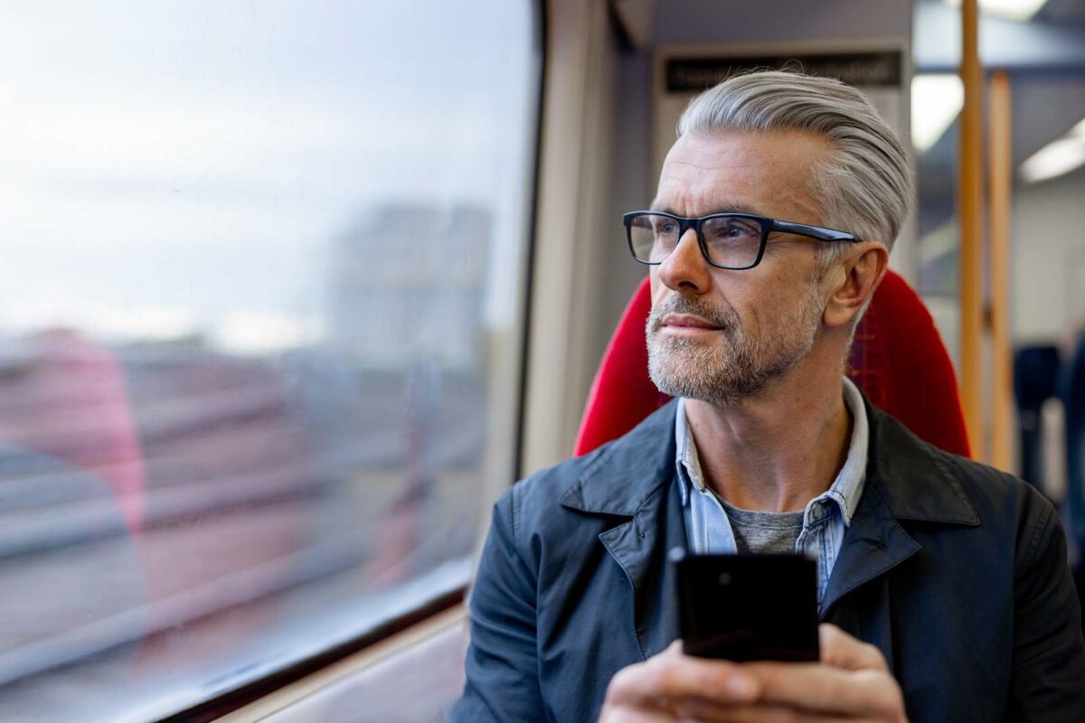 a man on a train looking at his cell phone.