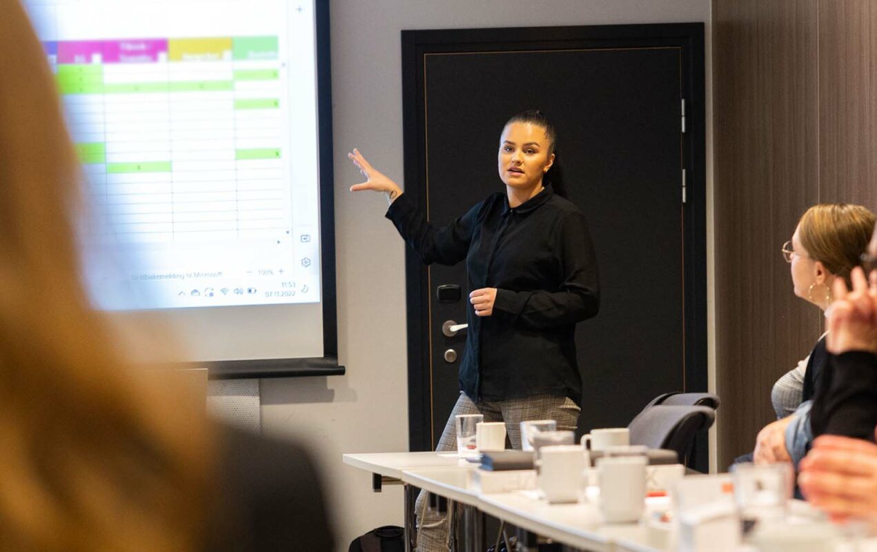 a woman giving a presentation to a group of people.